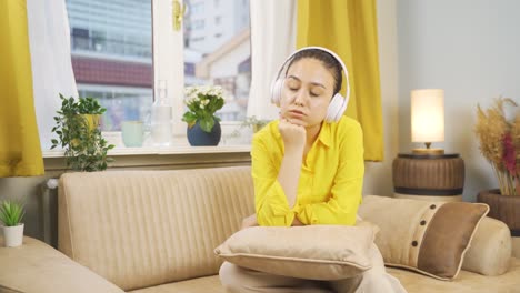 Unhappy-young-woman-listening-to-music-with-headphones.